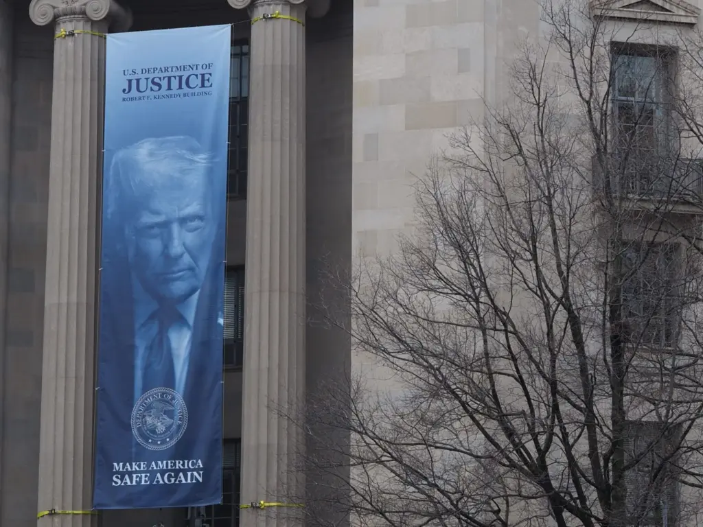 A banner showing President Donald Trump hangs on the Robert F. Kennedy Building of the U.S. Department of Justice on Feb. 20, 2026. (Photo by Shauneen Miranda/States Newsroom)