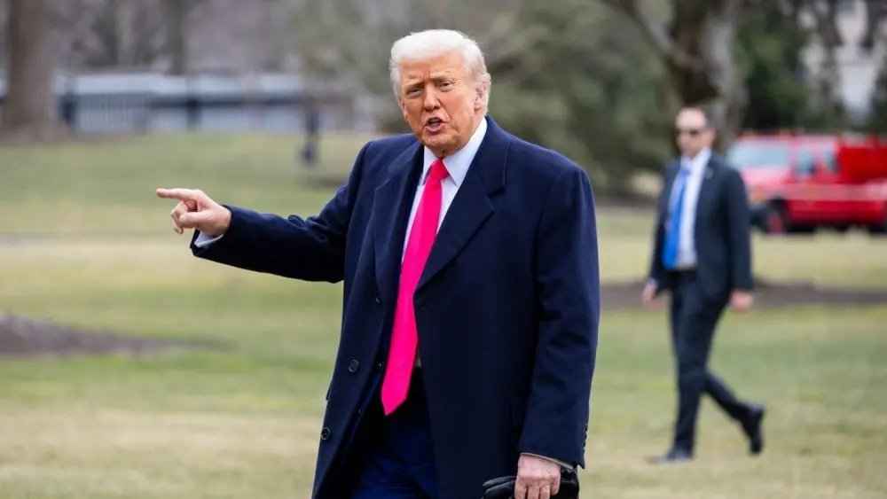 President Donald Trump points while on the South Lawn as he walks into the White House. WASHINGTON – February 22^ 2025