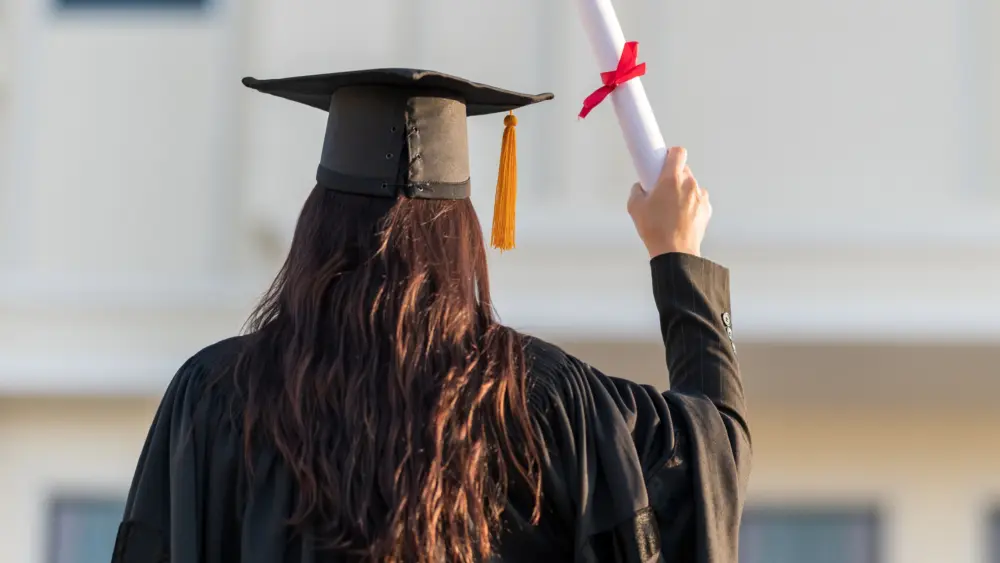 Graduates wear a black hat to stand for congratulations on graduation.- Schweitzer Engineering Laboratories (SEL)