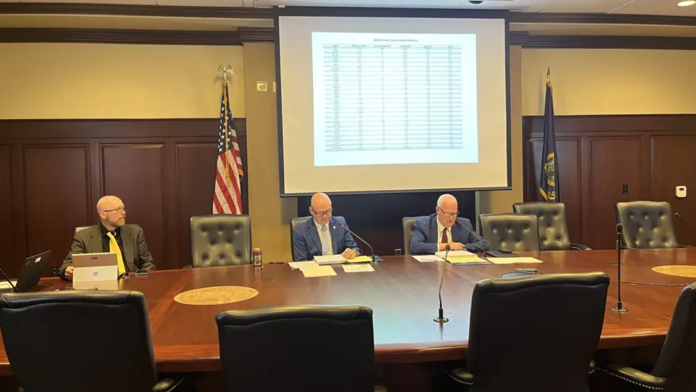 Idaho Secretary of State Phil McGrane, center, and Idaho State Controller Brandon Woolf, right, certify Idaho’s 2026 primary election results on June 9, 2026, at the Idaho State Capitol in Boise. (Photo by Clark Corbin/Idaho Capital Sun)