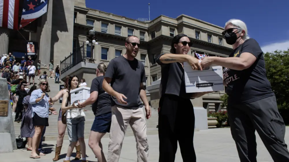 Volunteers pass boxes of signatures supporting a ballot initiative to end Idaho’s strict ban on abortion on July 2, 2026, outside the state Capitol in Boise. (Photo by Abigail Gerstein/Idaho Capital Sun)