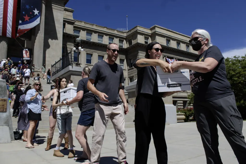 Volunteers pass boxes of signatures supporting a ballot initiative to end Idaho’s strict ban on abortion on July 2, 2026, outside the state Capitol in Boise. (Photo by Abigail Gerstein/Idaho Capital Sun)