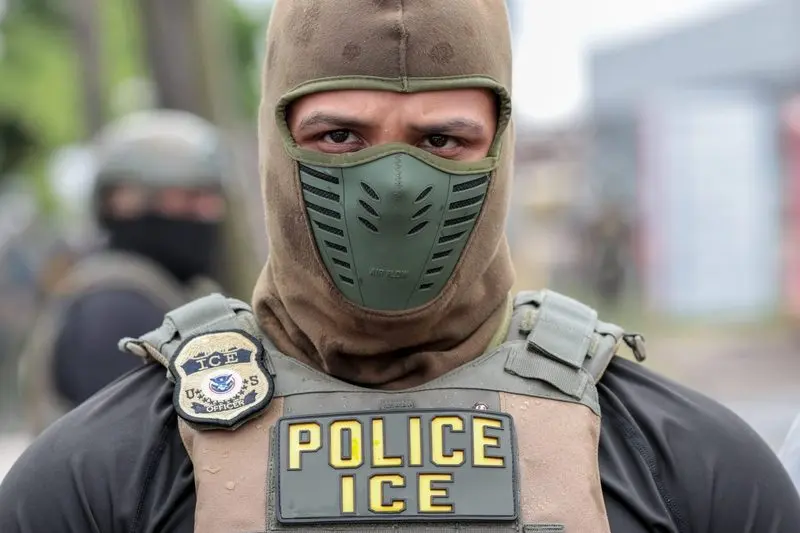 A U.S. Immigration and Customs Enforcement officer watches a crowd of protesters at Delaney Hall, a detention center, in Newark, New Jersey, on May 25, 2026. Employing new tactics, ICE arrested more people in July than in any previous month of the Trump administration. (Photo by Ben Ackman/New Jersey Monitor)