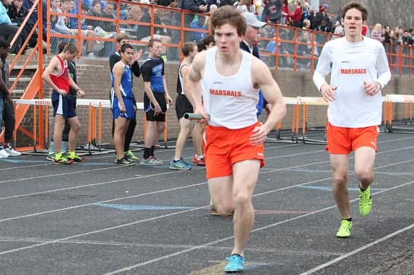 Dax Park hands the baton off to Robert Blankenship in the 4 x 800 meter relay in which they took first.