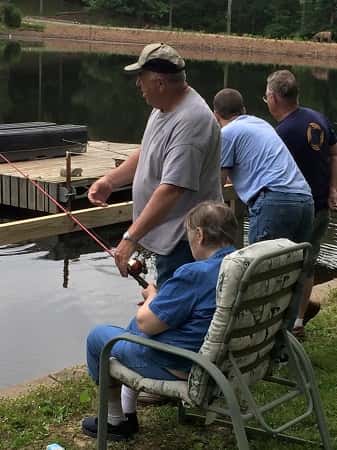 Billy Pat (standing left) assists clients of the Exceptional Center while fishing