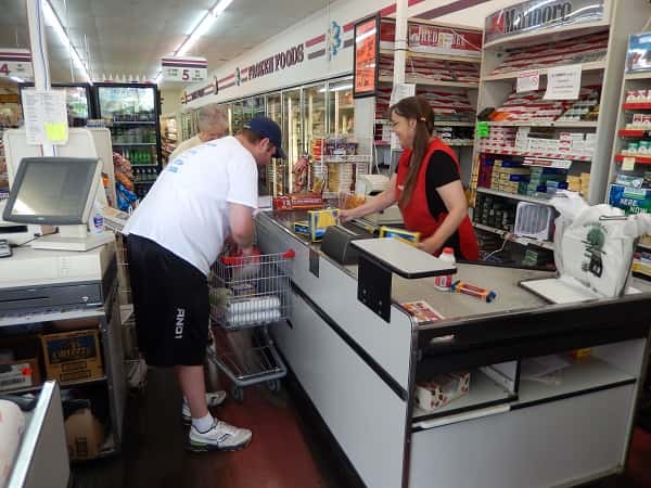 King Brothers Supermarket employees assist a customer with her groceries in the Draffenville location.