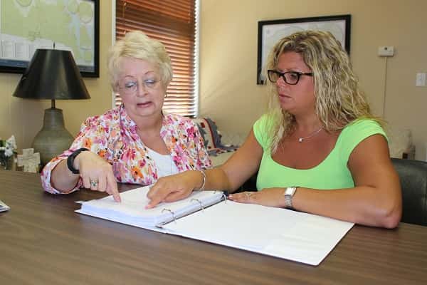 Judge Executive Chyrill Miller (left) and Treasurer Emily Martin read over Kentucky statutes governing retail alcohol sales.