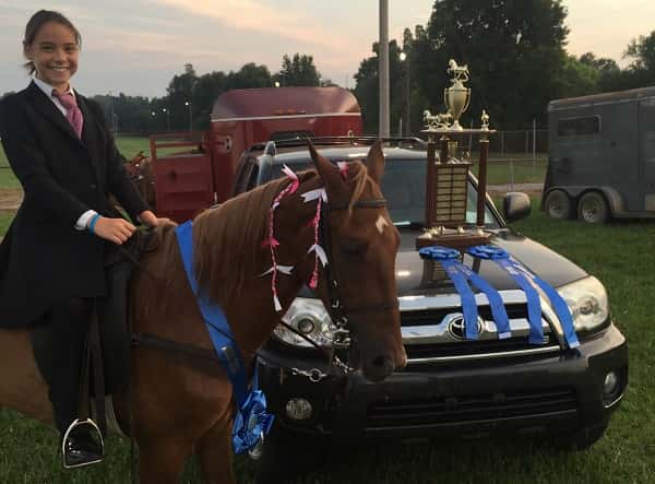 Mia Jaco and her horse, Milo, pose with the blue ribbons and trophy they won Aug. 25.