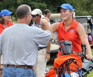 Bailey is greeted with a fist pump and hug from her dad after coming off the 18th green.