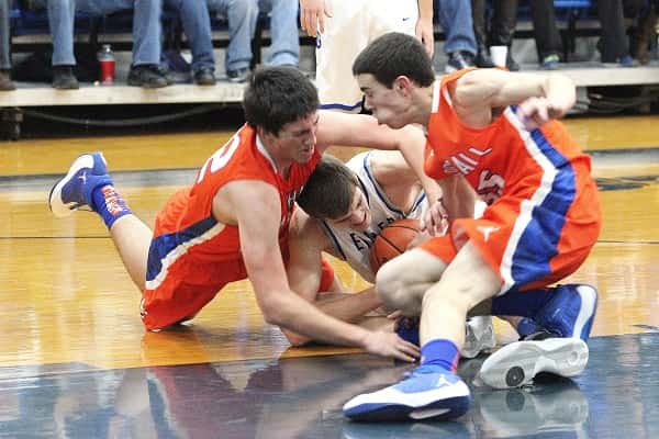 Matthew French (left) and Aaron Reed battle on the floor for the ball with Graves County's Chris Vogt.