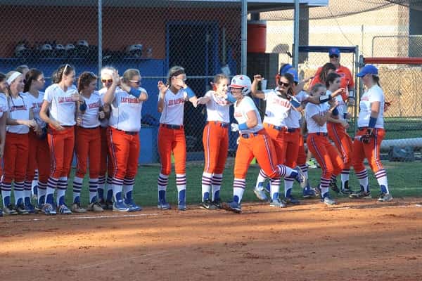 Payton Smothers is greeted by her teammates as she makes her way to home plate following her grand slam.
