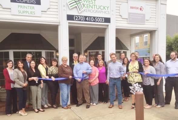 Many friends, family and fellow Chamber members were on hand to help cut the ribbon to kick off the Grand Opening Celebration of West Kentucky Xeroxgraphics on Wednesday May 18th. Jim Dema – Owner and wife Sandra to his left are pictured in the center (w/scissors).