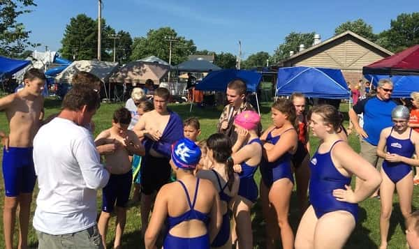 Several members of the Orange Waves listen to instructions from Coach Melvin Gordon at the Anna Invitational. Photos by Dena Moshure