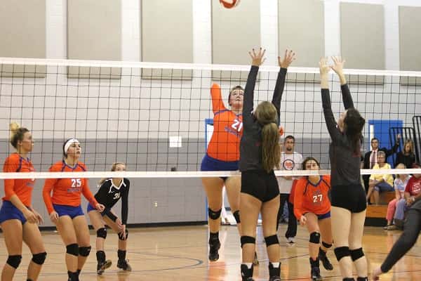 Ragan Harris goes up at the net for the kill against a couple of Lady Mustang blockers.