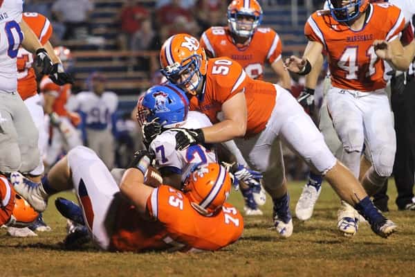 Brent Weitlauf (75) and Bryson Jessup (50) bring down Christian County's Trequan Haskins-Taylor.