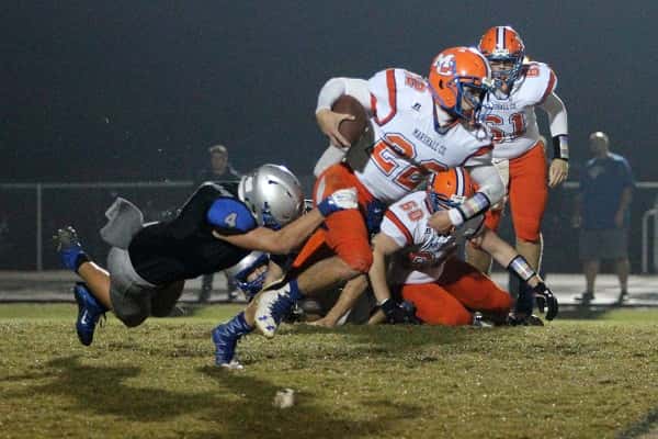 Cody Goatley (4) tries to stop the run of Mason Green (22) in Friday's 1st District game between the Marshals and Eagles.