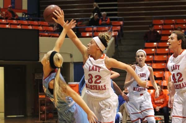 Paige Henson (32) gets her hand on the ball to keep it in the possession of the Lady Marshals.