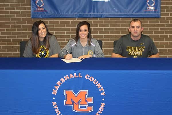 Kayla Travis signs her National Letter of Intent to play soccer for Murray State, joined by her parents Jenny and Marvin.