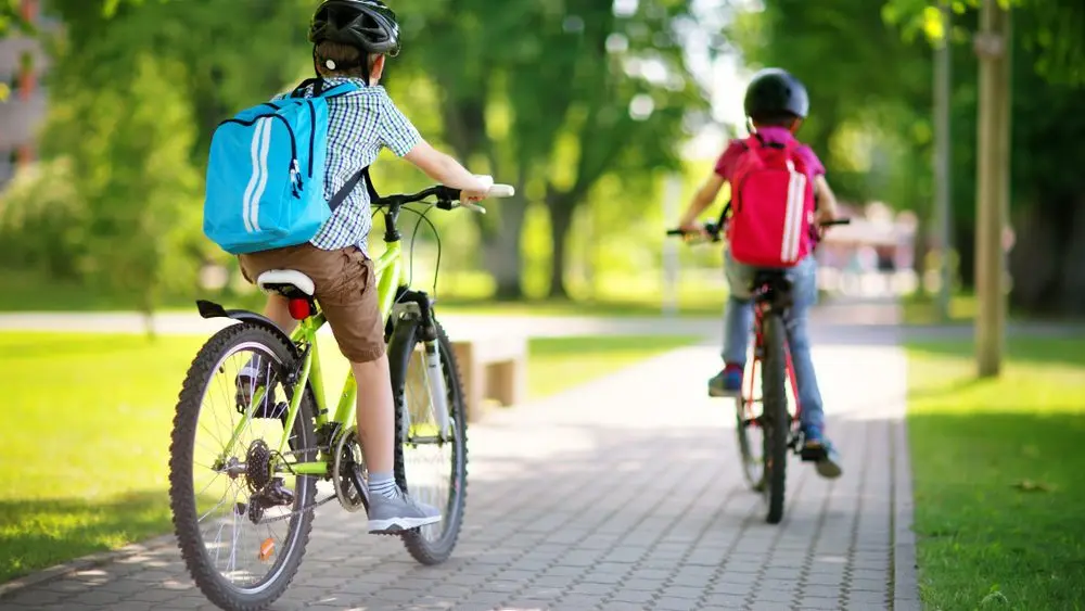 childrenwithrucksacksridingonbikesintheparknear