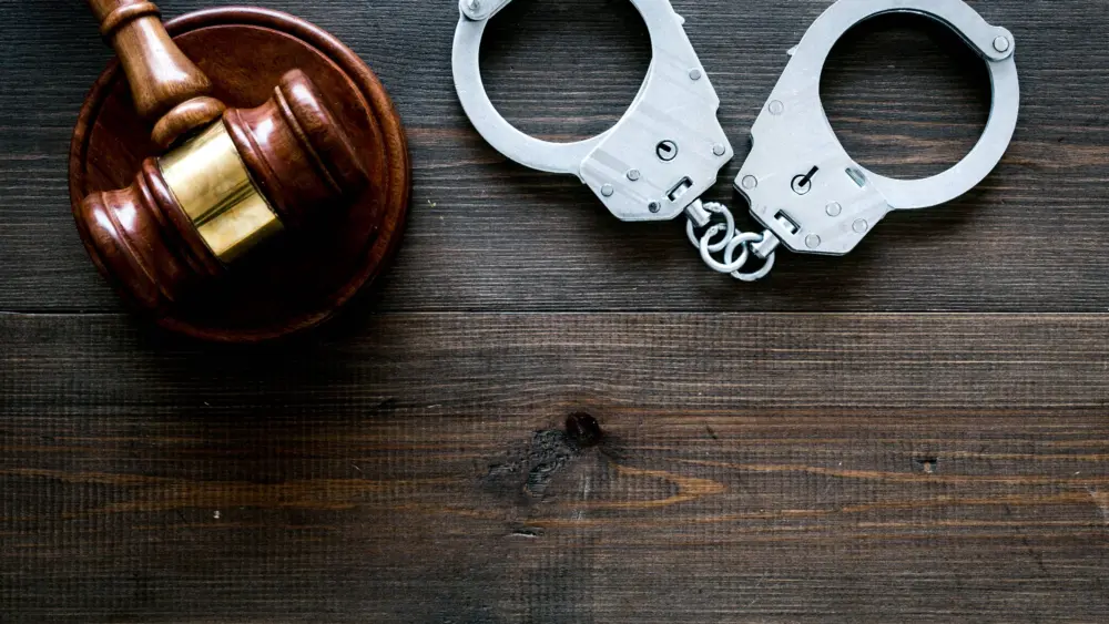 arrestconcept-metalhandcuffsnearjudgegavelondarkwooden
