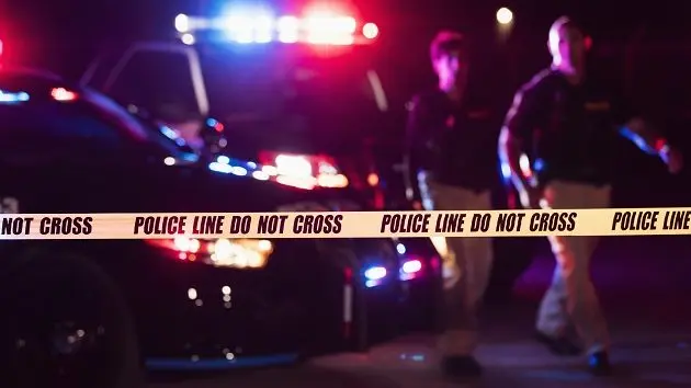 two-police-officers-behind-crime-scene-tape