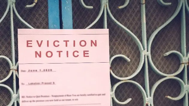 foreclosed-or-eviciton-notice-on-a-main-door-with-blurred-details-of-a-house-with-vintage-filter
