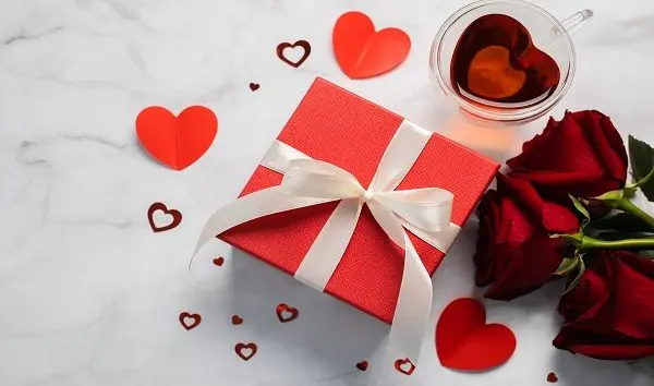 valentines-day-background-gift-box-red-roses-hot-tea-in-cup-and-aper-hearts-on-background-flat-lay-directly-above-copy-space