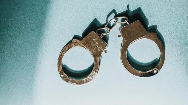 simple-conceptual-image-of-silver-handcuffs-on-blue-surface-2