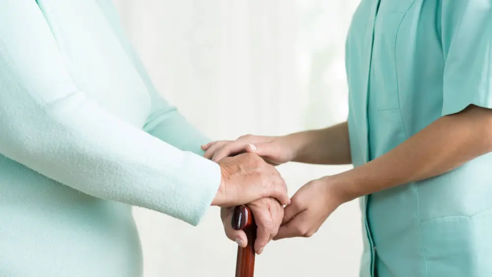 closeupofcaregiverholdinghandofoldfemale