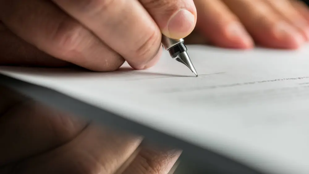 closeupofmalehandabouttosignabusinesscontract