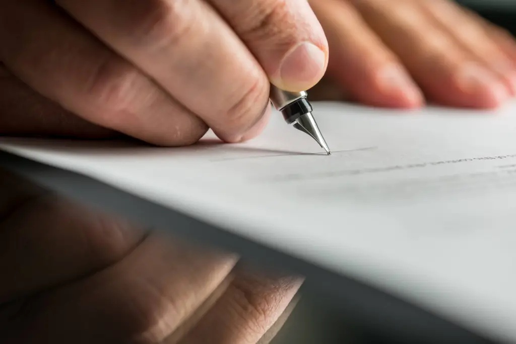 closeupofmalehandabouttosignabusinesscontract