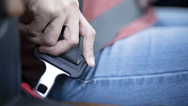 car-safety-concept-close-up-of-hand-woman-pulling-seat-belt-in-her-car