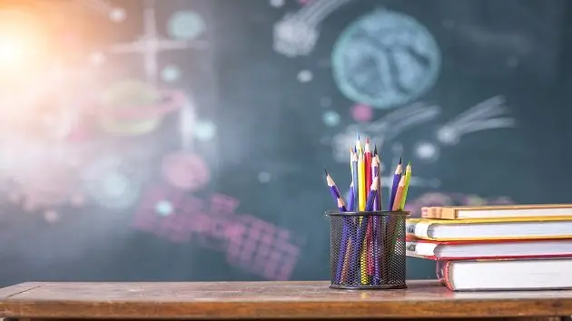 book-and-colored-pencil-on-school-table