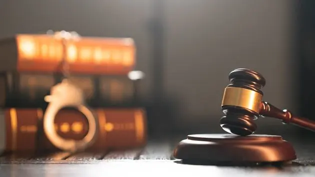 glittering-handcuffs-on-books-and-law-hammer