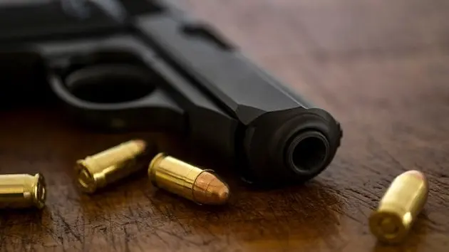 gold-bullets-and-pistol-on-wooden-surface-2