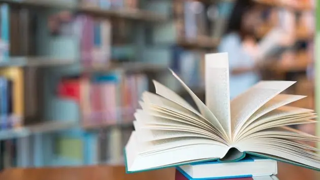book-in-library-with-old-open-textbook