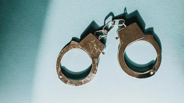simple-conceptual-image-of-silver-handcuffs-on-blue-surface-3