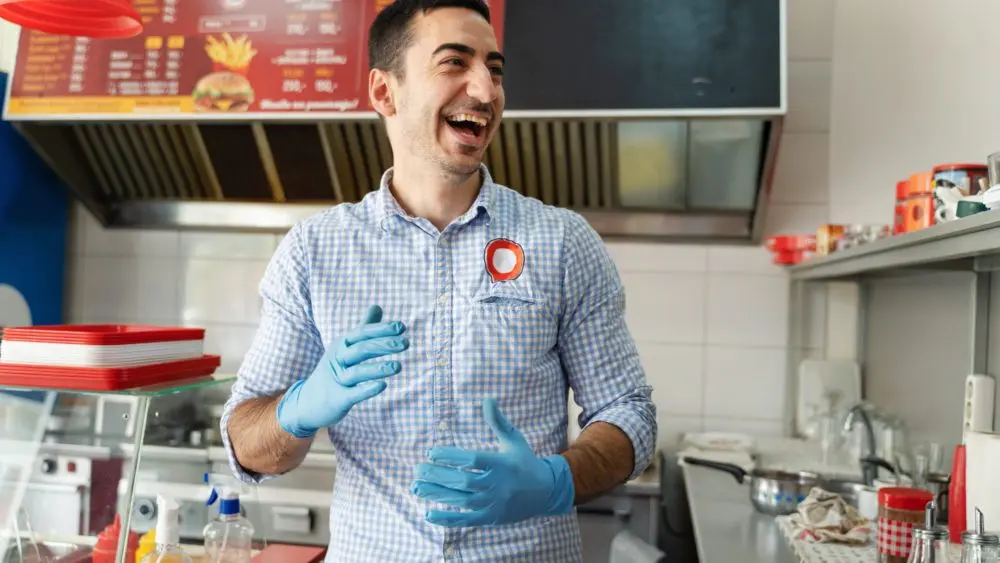 youngadultcaucasianmanentrepreneurstandingathisfastfood