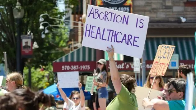 a-woman-holds-a-placard-saying-abortion-is-healthcare