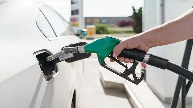 mans-hand-holding-green-petrol-pump-and-feeling-car