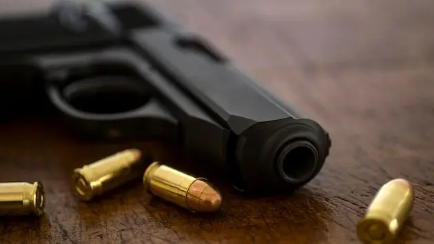 gold-bullets-and-pistol-on-wooden-surface-3