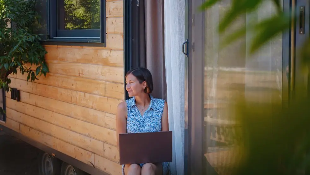 happyyoungasianwomanwithlaptoprestingoutdoorsneartiny