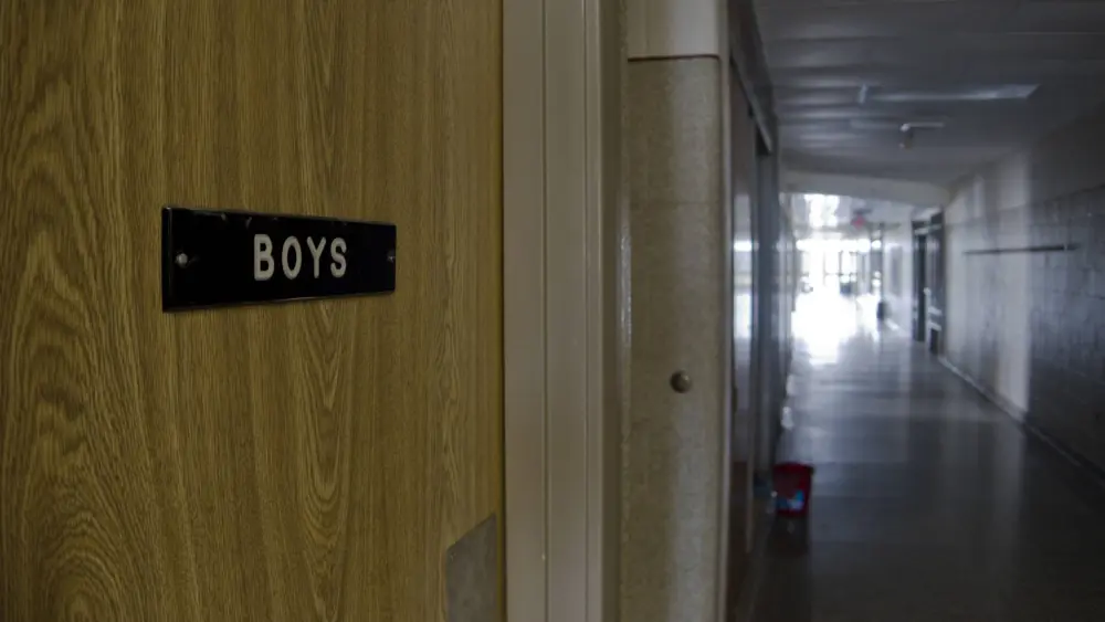 boys-restroom-door-in-empty-school-hallway