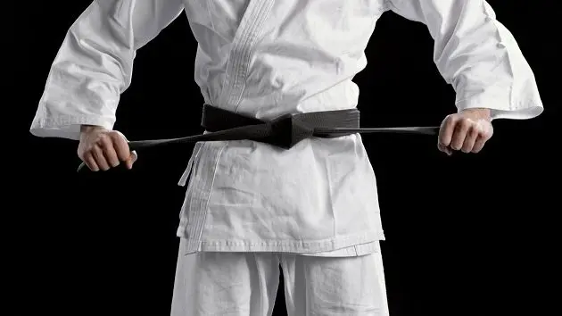 male-karate-player-standing-against-black-background