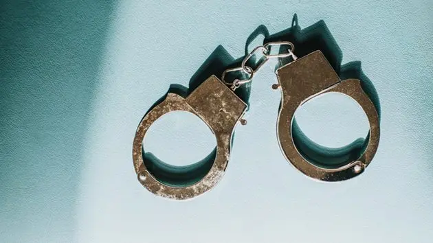simple-conceptual-image-of-silver-handcuffs-on-blue-surface-11