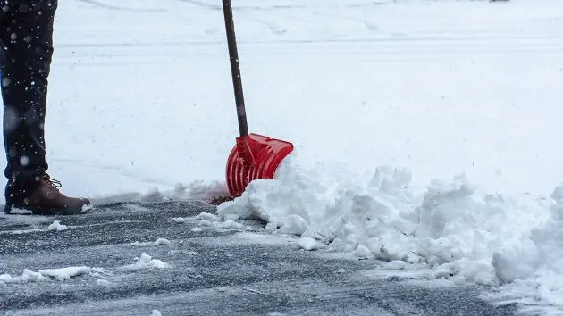 man-cleaning-the-sidewalk-covered-in-snow