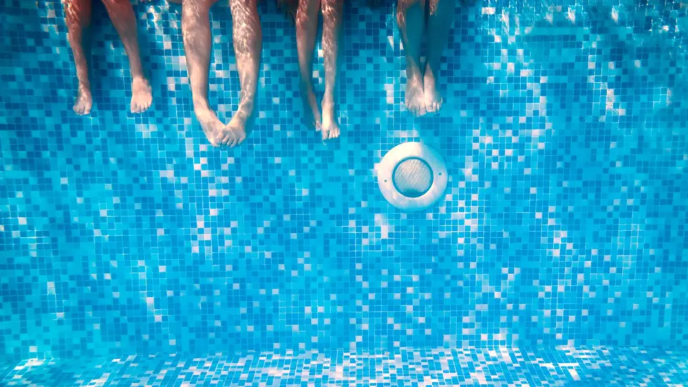childrensandadultslegsunderwaterintheswimmingpool