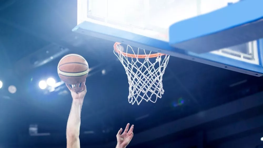 Ball in hoop at basketball game. Athletic competitions and games concept.