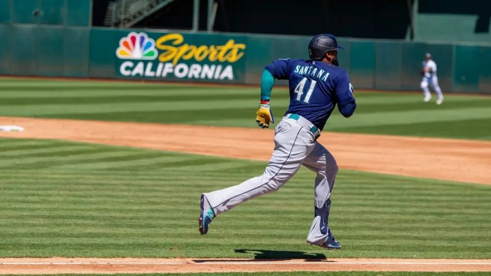 Seattle Mariners infielder Carlos Santana runs to first base against the Oakland Athletics at the Oakland Coliseum. Oakland^ California - August 21^ 2022