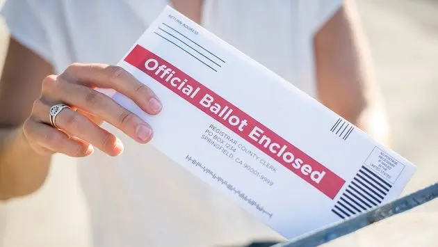 woman-mailing-her-absentee-voter-ballot